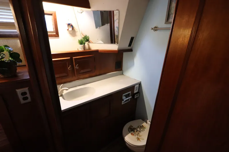 Slide: The Image of Bathroom interior of 1985 Viking 50 Cockpit Motor Yacht with wooden cabinetry and sink. - 51