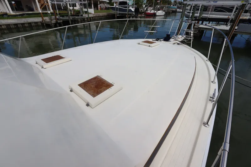 Slide: The Image of 1985 Viking 50 Cockpit Motor Yacht deck view, featuring hatches and railing in a marina setting. - 14