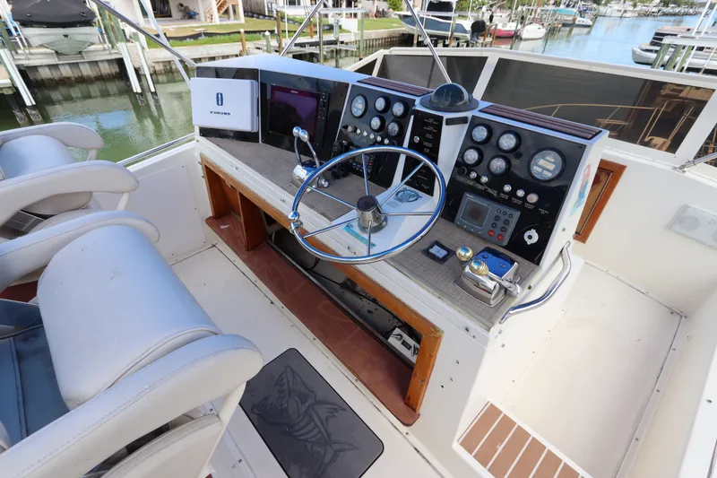 Slide: The Image of Cockpit of 1985 Viking 50 Cockpit Motor Yacht with steering wheel and control panel. - 16