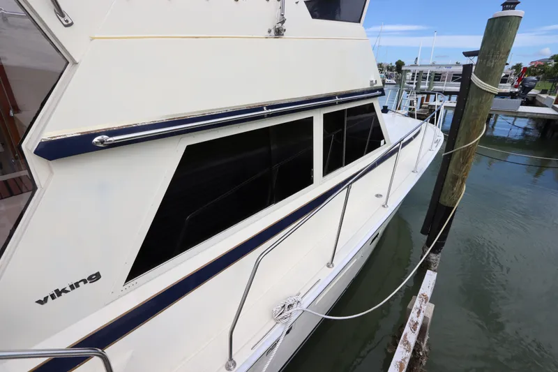 Slide: The Image of 1985 Viking 50 Cockpit Motor Yacht docked at marina, side view. - 13