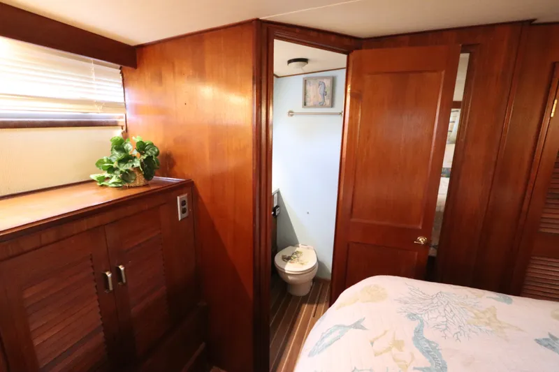 Slide: The Image of 1985 Viking 50 Cockpit Motor Yacht interior with wooden cabinetry and bathroom. - 50