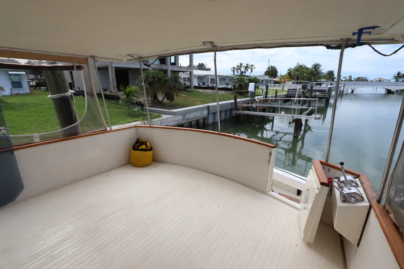 Slide: The Image of 1985 Viking 50 Cockpit Motor Yacht deck overlooking serene waterfront and dock area. - 4