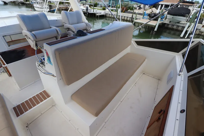 Slide: The Image of 1985 Viking 50 Cockpit Motor Yacht interior with cushioned seating and helm chairs. - 21