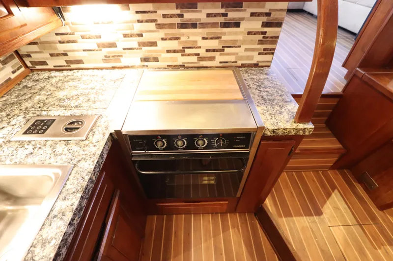 Slide: The Image of 1985 Viking 50 Cockpit Motor Yacht kitchen with granite countertops and wood flooring. - 34