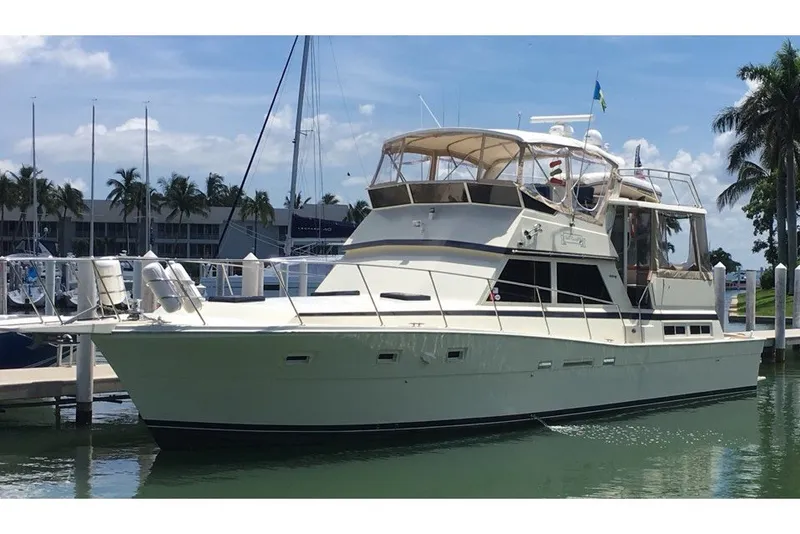 Slide: The Image of 1985 Viking 50 Cockpit Motor Yacht docked in a sunny marina setting. - 2