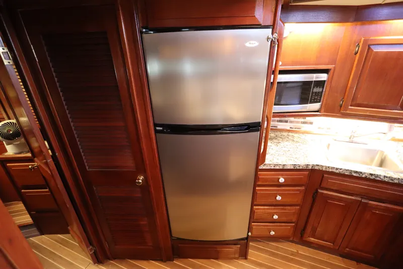 Slide: The Image of Interior of 1985 Viking 50 Cockpit Motor Yacht kitchen with stainless steel fridge. - 30