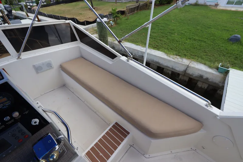 Slide: The Image of 1985 Viking 50 Cockpit Motor Yacht interior with cushioned seating and control panel. - 20
