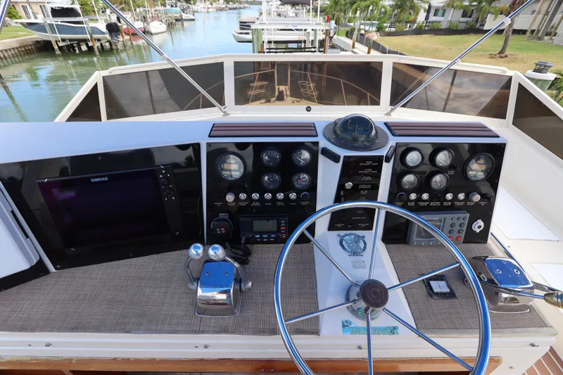 Slide: The Image of Cockpit view of 1985 Viking 50 Cockpit Motor Yacht with steering wheel and control panel. - 18