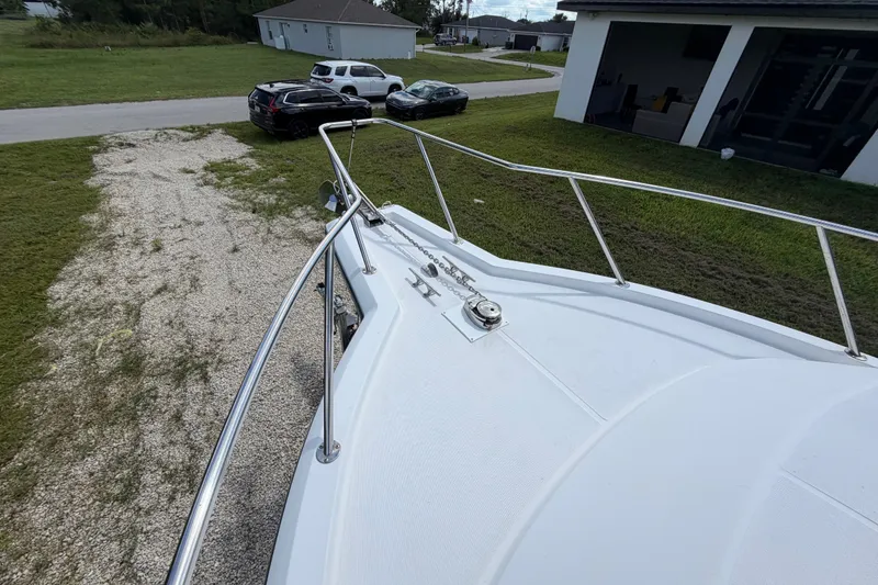 Slide: The Image of 2003 Stamas 290 Express boat bow with railing, parked near residential area. - 41