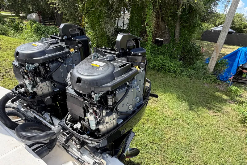 Slide: The Image of Twin outboard engines on a 2003 Stamas 290 Express boat, surrounded by greenery. - 40