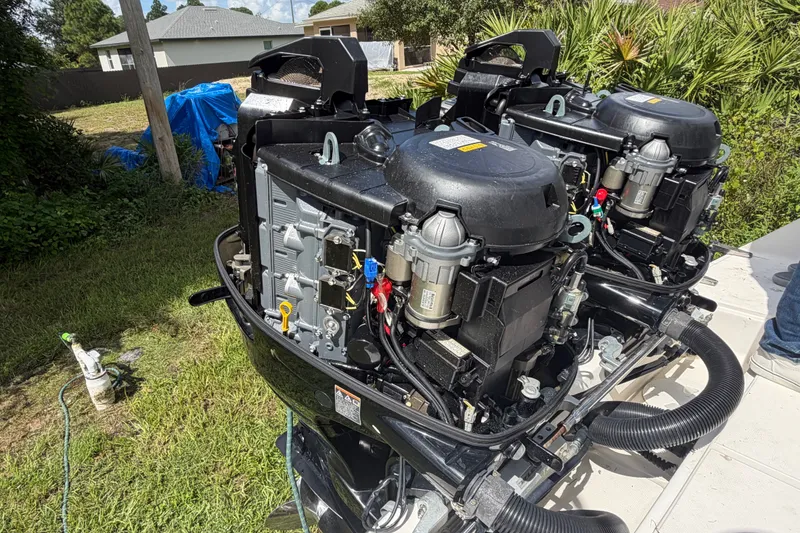 Slide: The Image of Two outboard engines on a 2003 Stamas 290 Express boat, surrounded by greenery. - 39
