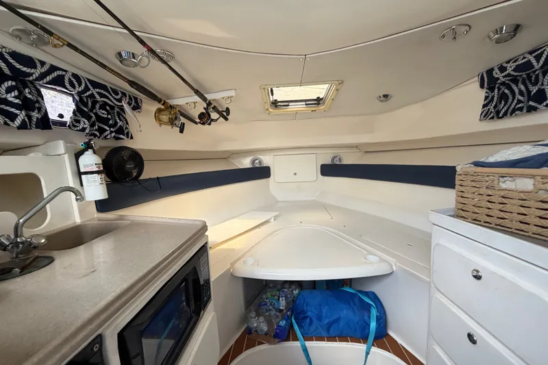 Slide: The Image of Interior of 2003 Stamas 290 Express boat with kitchenette and cozy seating area. - 14