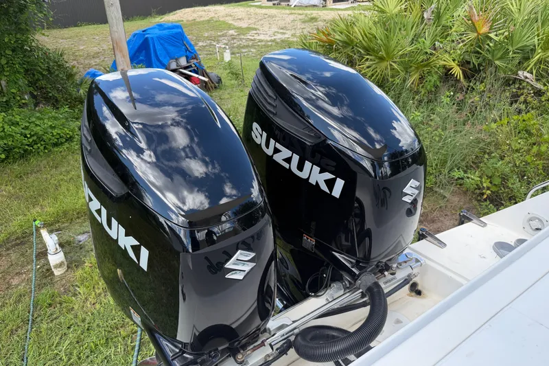 Slide: The Image of Twin Suzuki outboard motors on a 2003 Stamas 290 Express boat, surrounded by greenery. - 37