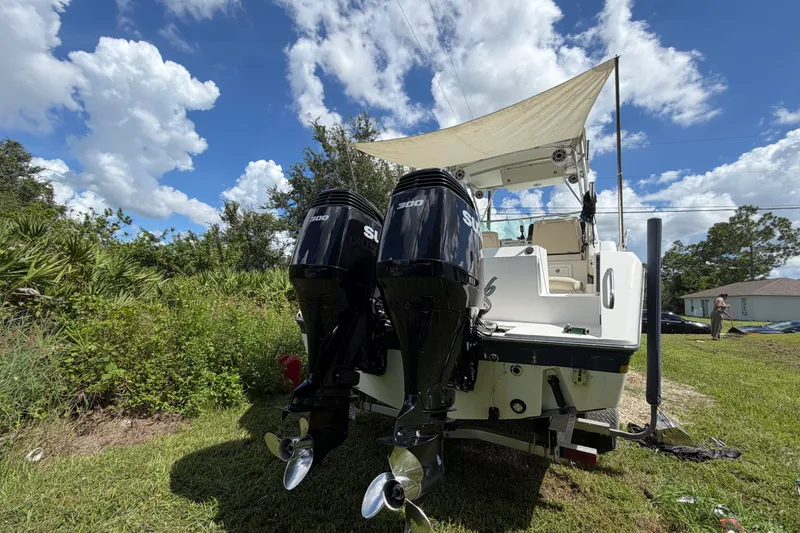 Slide: The Image of 2003 Stamas 290 Express boat with dual Suzuki outboard motors on grassy yard. - 36