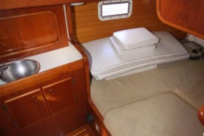 Slide: The Image of 1988 Sceptre 41 yacht interior with wooden cabinetry and compact sleeping area. - 18
