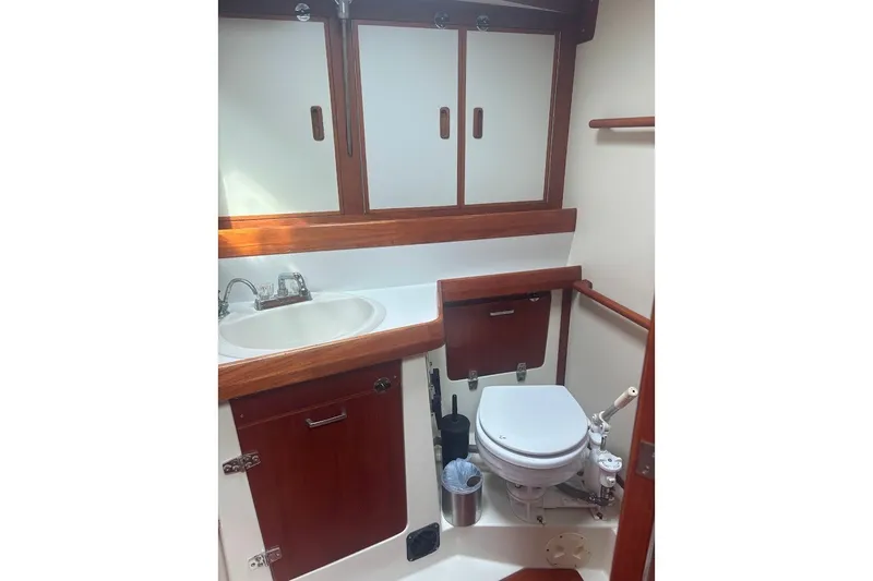 Slide: The Image of 1988 Sceptre 41 yacht bathroom with wooden cabinetry, sink, and marine toilet. - 17