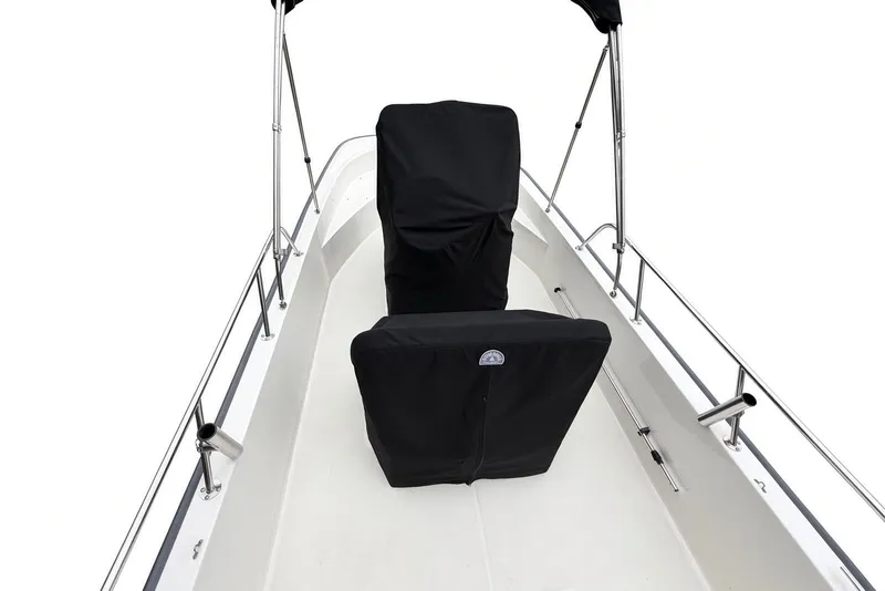 Slide: The Image of 2017 Boston Whaler 170 Montauk boat interior with black seat covers and stainless steel railings. - 18