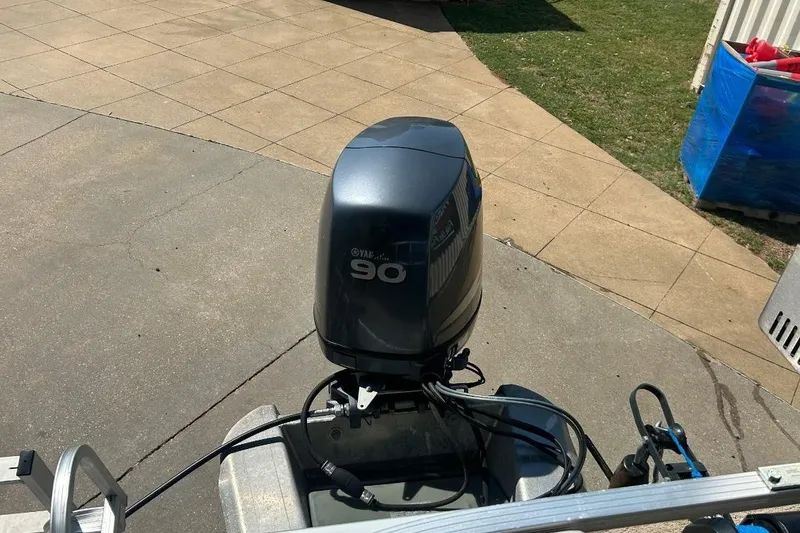 Slide: The Image of Outboard motor on a 2011 Bennington 24 SFi boat, parked on a paved surface. - 6