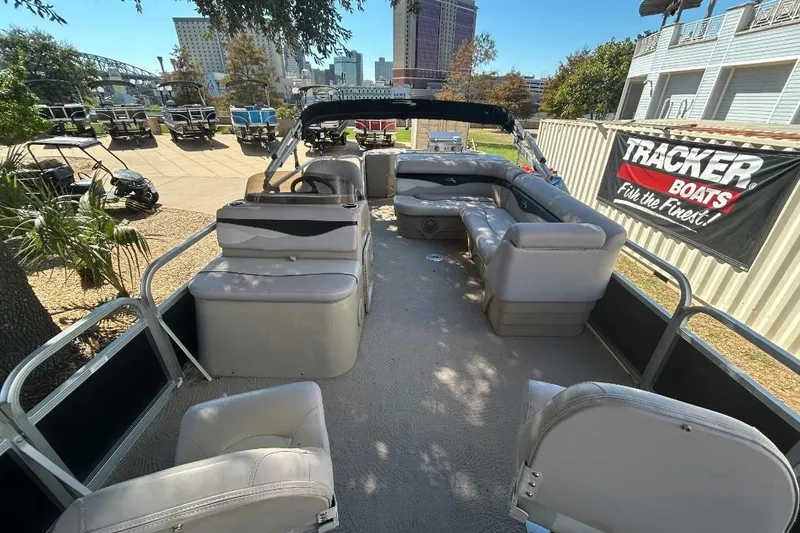 Slide: The Image of 2011 Bennington 24 SFi pontoon boat with spacious seating, parked outdoors. - 4
