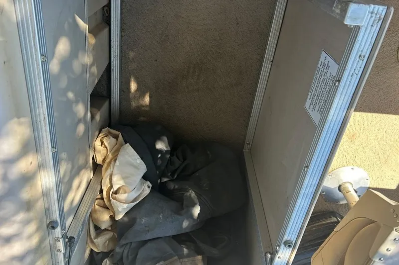 Slide: The Image of Open storage compartment on a 2011 Bennington 24 SFi boat with fabric inside. - 24