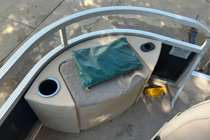 Slide: The Image of 2011 Bennington 24 SFi boat interior with cup holder and green cover. - 22
