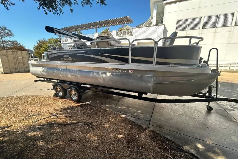 Slide: The Image of 2011 Bennington 24 SFi pontoon boat on trailer, parked outdoors. - 1