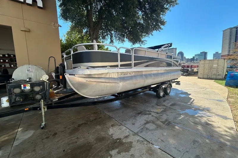 Slide: The Image of 2011 Bennington 24 SFi pontoon boat on trailer, parked outdoors near a building. - 3