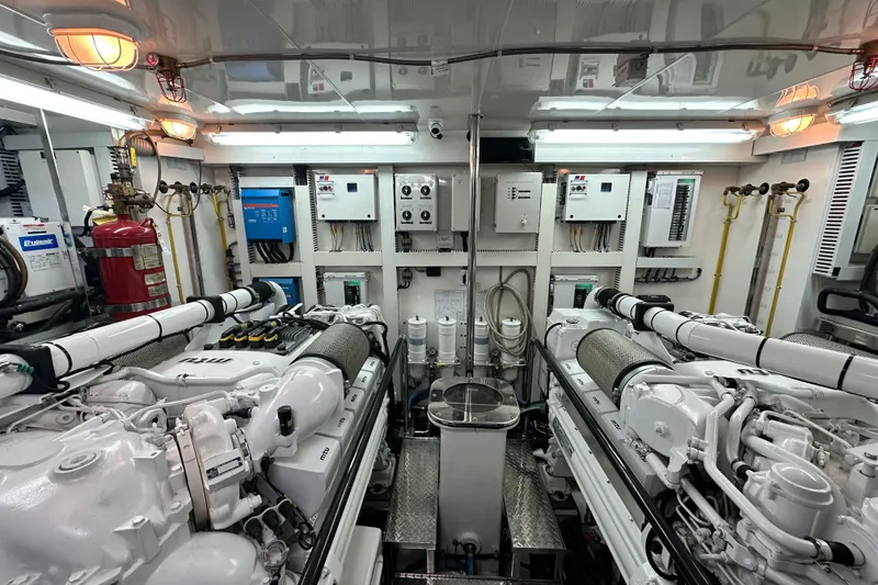 Slide: The Image of Engine room of a 2012 Ocean Alexander 85 E yacht, featuring dual engines and control panels. - 102