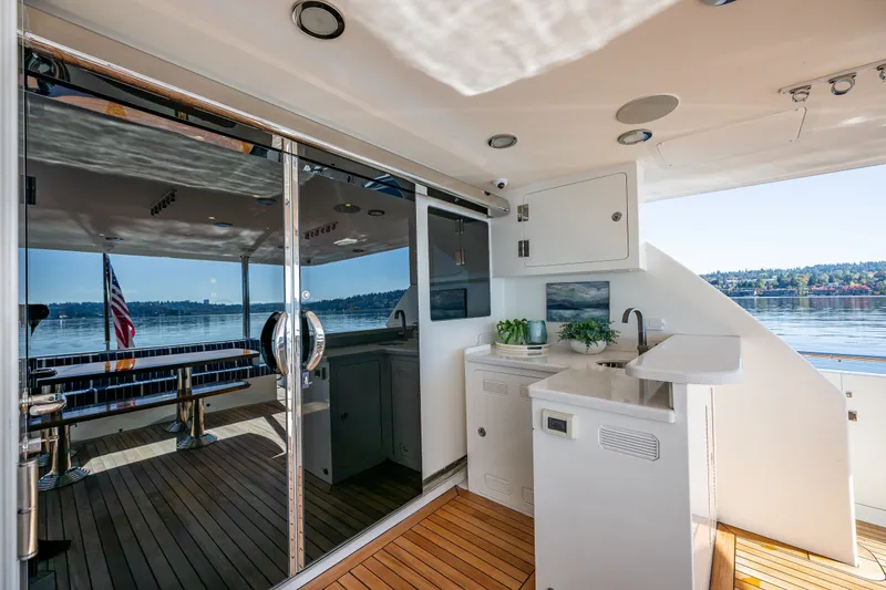 Slide: The Image of Luxurious Ocean Alexander 85 E yacht deck with kitchenette, sleek design, and scenic water view. - 76