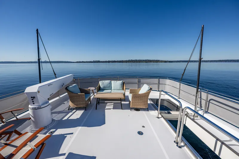 Slide: The Image of Luxurious 2012 Ocean Alexander 85 E yacht deck with seating, overlooking serene waters. - 85