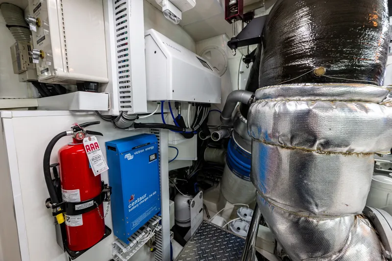 Slide: The Image of Engine room of 2012 Ocean Alexander 85 E yacht with equipment and fire extinguisher. - 112