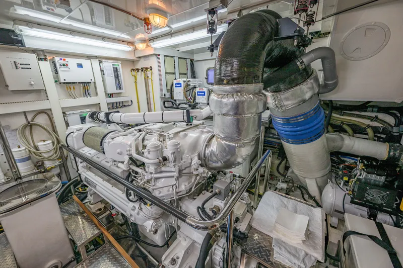 Slide: The Image of Engine room of 2012 Ocean Alexander 85 E yacht, showcasing complex machinery and piping. - 103