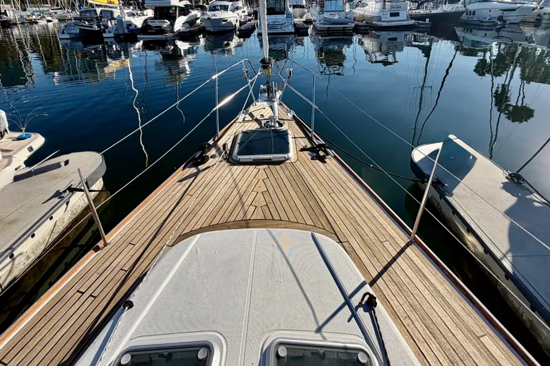 Slide: The Image of 2007 Jeanneau Sun Odyssey 49 DS yacht docked in marina, showcasing sleek wooden deck design. - 18