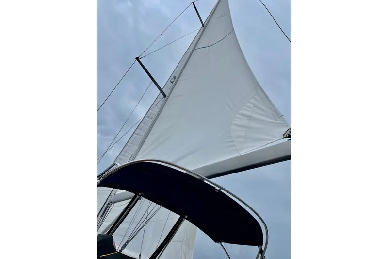 Slide: The Image of Sailing yacht Jeanneau Sun Odyssey 49 DS, 2007 model, with sails unfurled against a cloudy sky. - 107