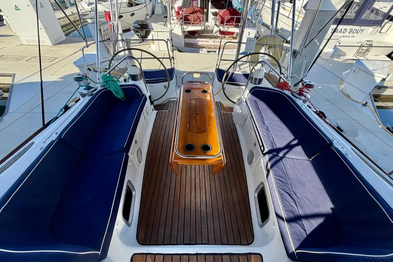 Slide: The Image of Cockpit of 2007 Jeanneau Sun Odyssey 49 DS sailboat with blue seating and wooden table. - 43