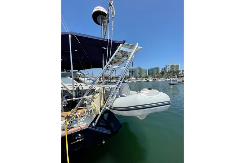 Slide: The Image of Jeanneau Sun Odyssey 49 DS 2007 yacht with dinghy, docked in a marina under clear blue sky. - 52