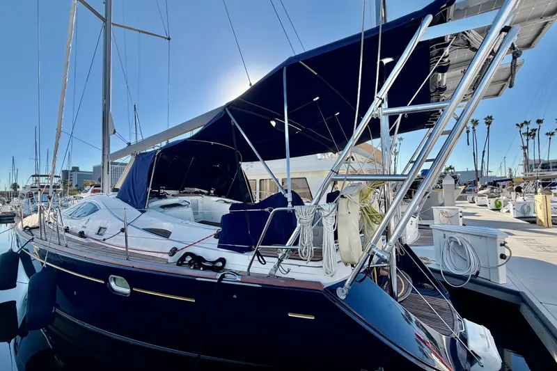 Slide: The Image of 2007 Jeanneau Sun Odyssey 49 DS sailboat docked in marina, featuring sleek design and blue canopy. - 11