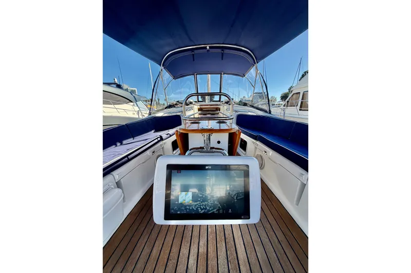 Slide: The Image of 2007 Jeanneau Sun Odyssey 49 DS cockpit with navigation display, blue seating, and wooden deck. - 31