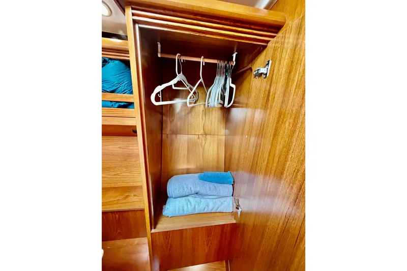 Slide: The Image of Wooden closet interior with hangers and folded towels on Jeanneau Sun Odyssey 49 DS, 2007 model. - 85