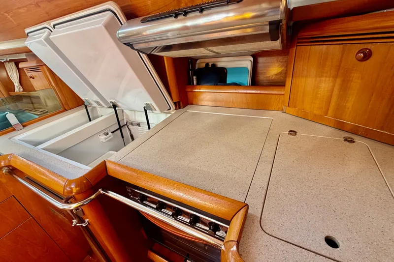 Slide: The Image of 2007 Jeanneau Sun Odyssey 49 DS yacht kitchen with stove, countertop, and storage. - 100