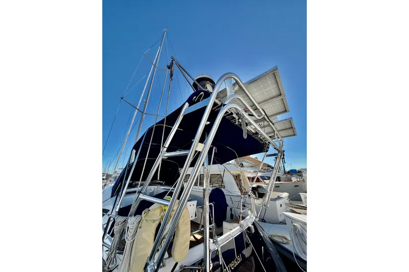 Slide: The Image of 2007 Jeanneau Sun Odyssey 49 DS sailboat with solar panels and rigging, docked under clear sky. - 49