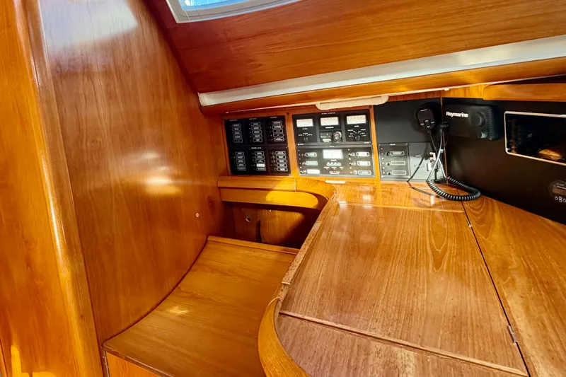 Slide: The Image of 2007 Jeanneau Sun Odyssey 49 DS interior navigation station with control panels and wood finish. - 63