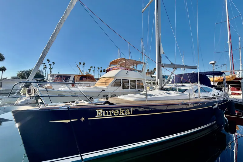 Slide: The Image of 2007 Jeanneau Sun Odyssey 49 DS sailboat named "Eureka!" docked in a sunny marina. - 2