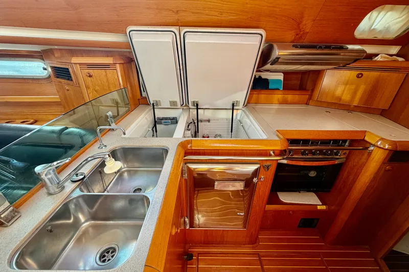 Slide: The Image of Luxurious 2007 Jeanneau Sun Odyssey 49 DS yacht kitchen with wood cabinetry and stainless steel sink. - 77