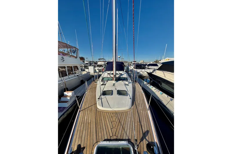 Slide: The Image of 2007 Jeanneau Sun Odyssey 49 DS sailboat docked in a marina, showcasing its sleek deck design. - 22