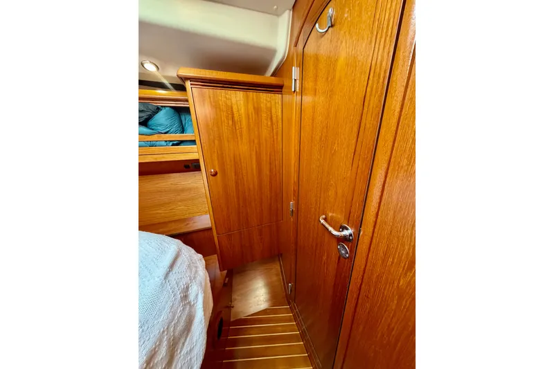 Slide: The Image of Interior of 2007 Jeanneau Sun Odyssey 49 DS, featuring wooden cabinetry and cozy sleeping area. - 83