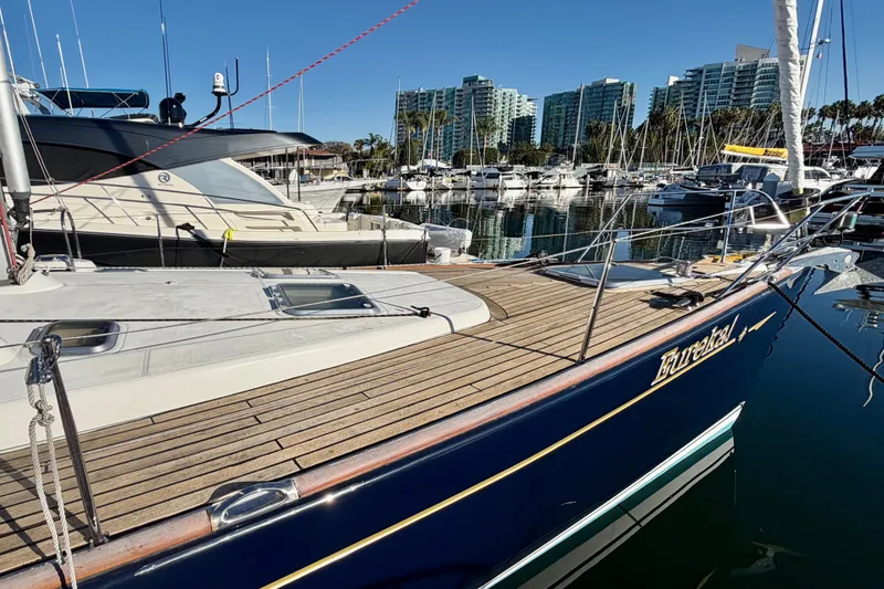 Slide: The Image of 2007 Jeanneau Sun Odyssey 49 DS sailboat docked in a marina with cityscape background. - 6