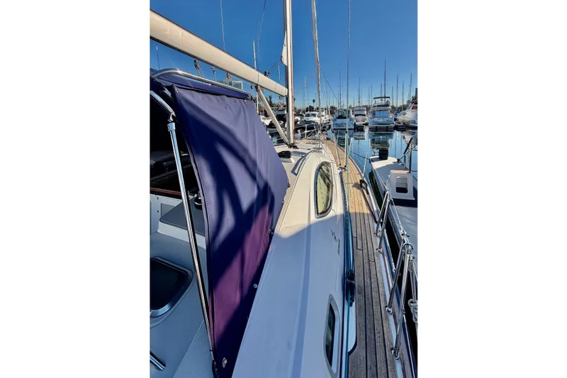 Slide: The Image of 2007 Jeanneau Sun Odyssey 49 DS sailboat docked in a marina, showcasing deck and rigging. - 16