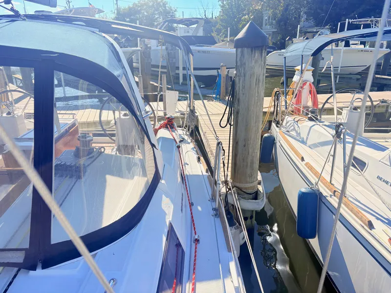Slide: The Image of A 2020 Beneteau Oceanis 35.1 docked in a sunny marina, surrounded by other boats. - 15