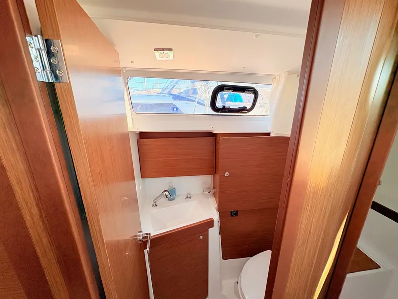 Slide: The Image of The image shows the bathroom of a 2020 Beneteau Oceanis 35.1 with wood paneling. - 19